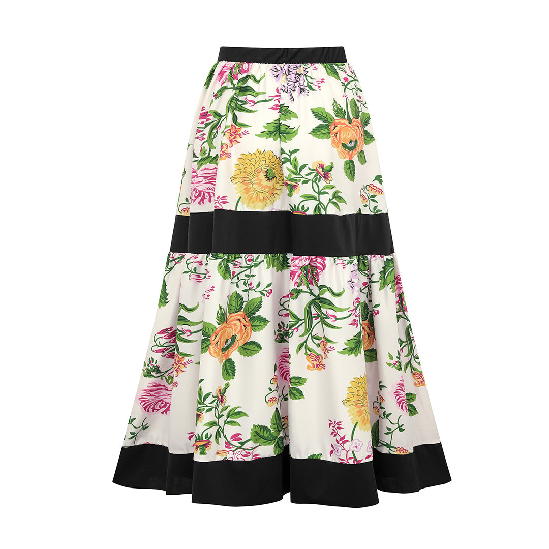 One-piece swimsuit with dropped shoulder straps, tie back, color block print and skirt