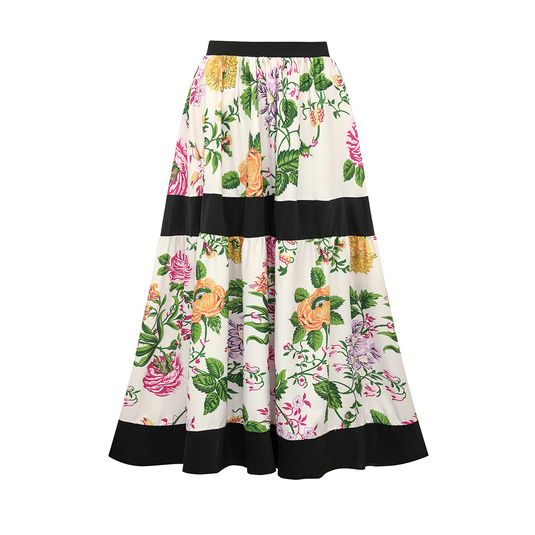 One-piece swimsuit with dropped shoulder straps, tie back, color block print and skirt