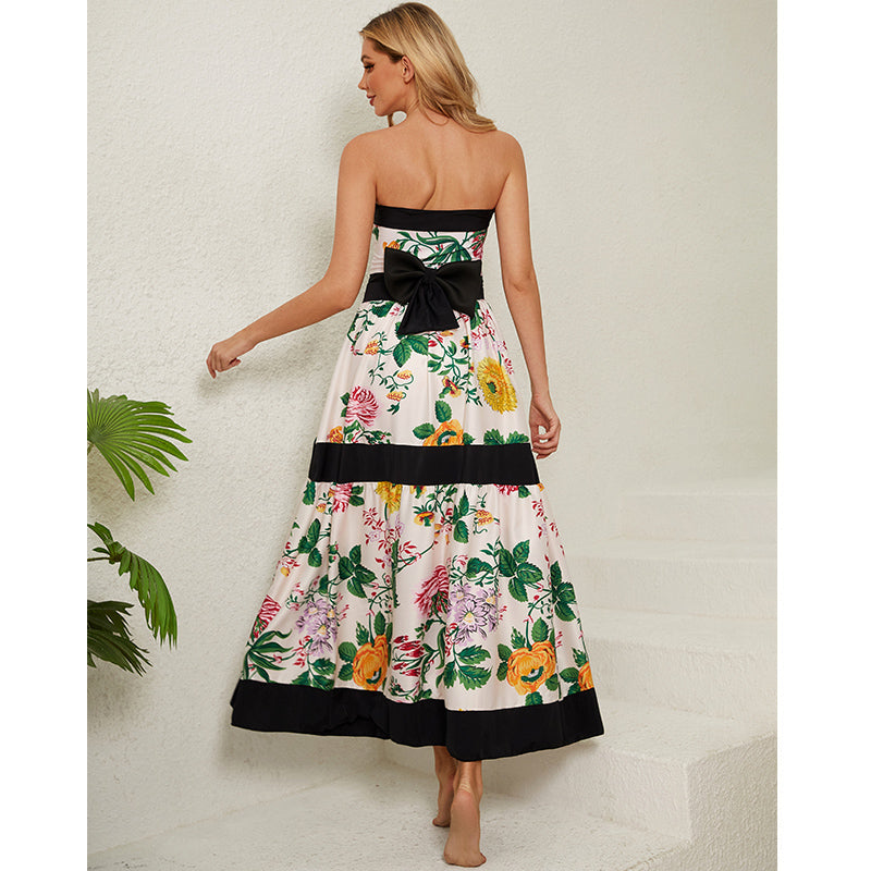 One-piece swimsuit with dropped shoulder straps, tie back, color block print and skirt