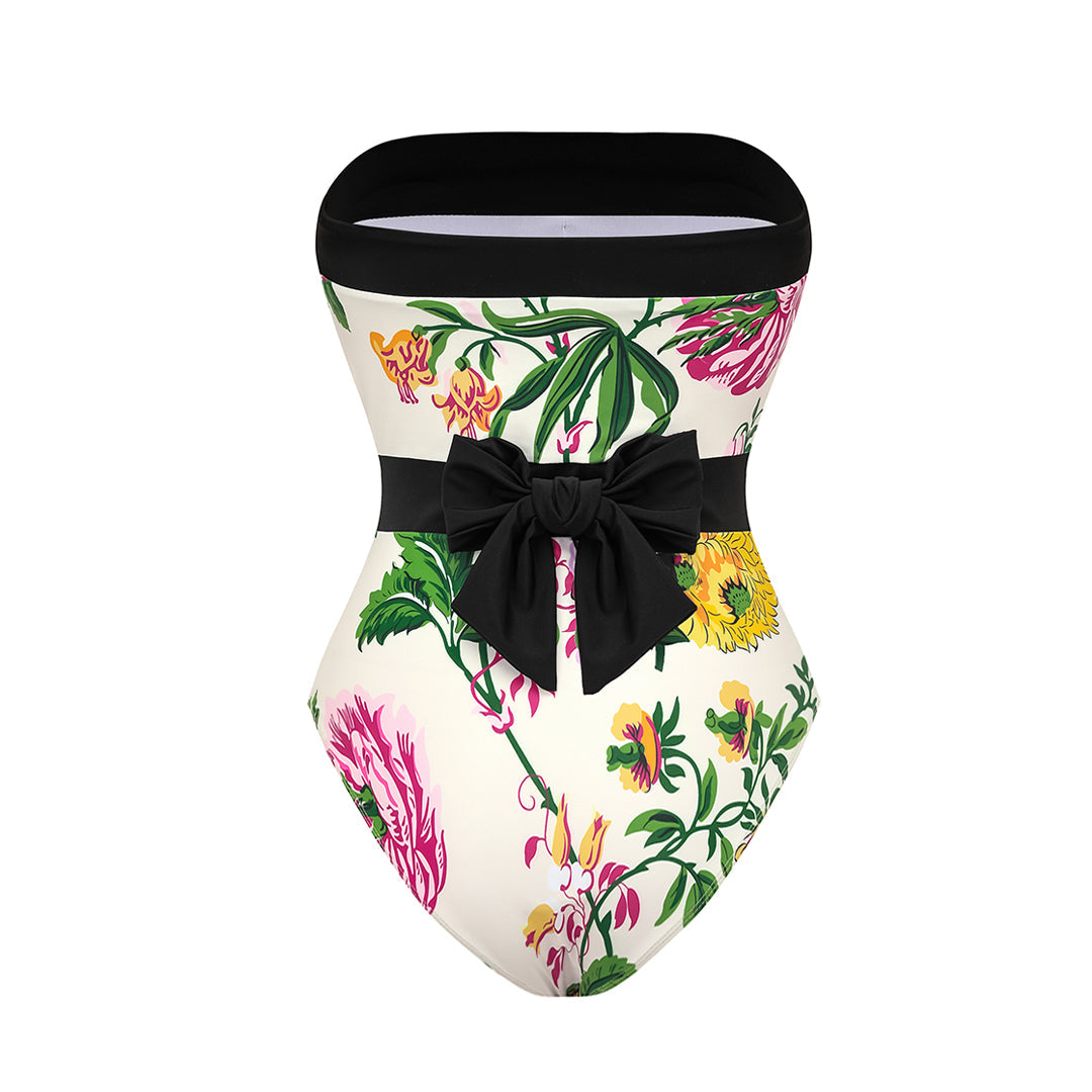 One-piece swimsuit with dropped shoulder straps, tie back, color block print and skirt