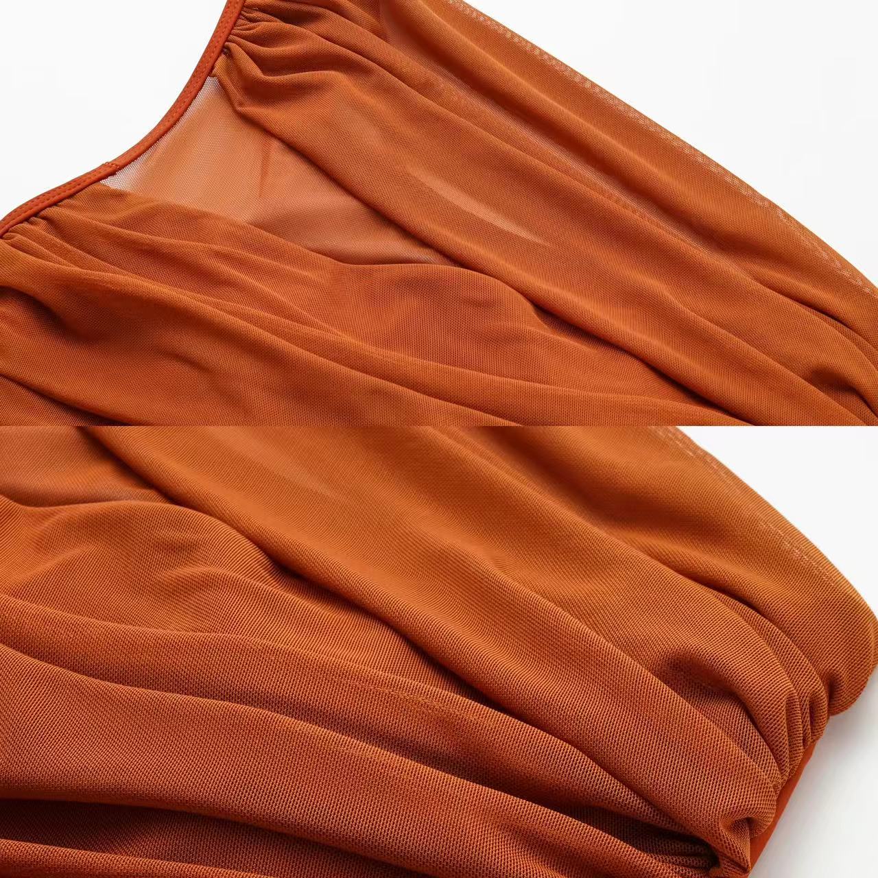 A crinkled one-sleeve swimsuit in sheer rust and a sarong