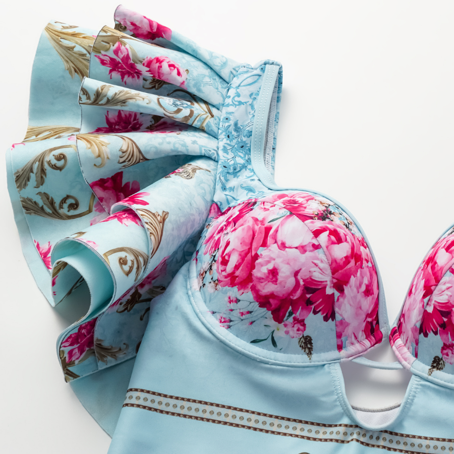 One-piece swimsuit with a curly blue floral print and skirt