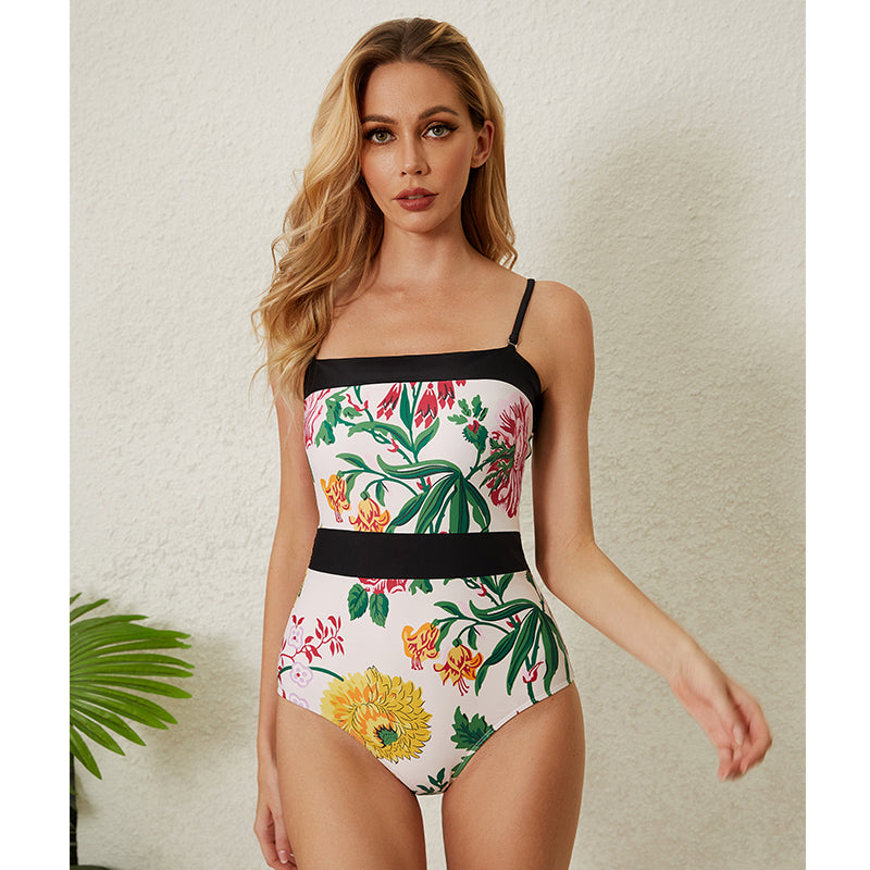 One-piece swimsuit with dropped shoulder straps, tie back, color block print and skirt