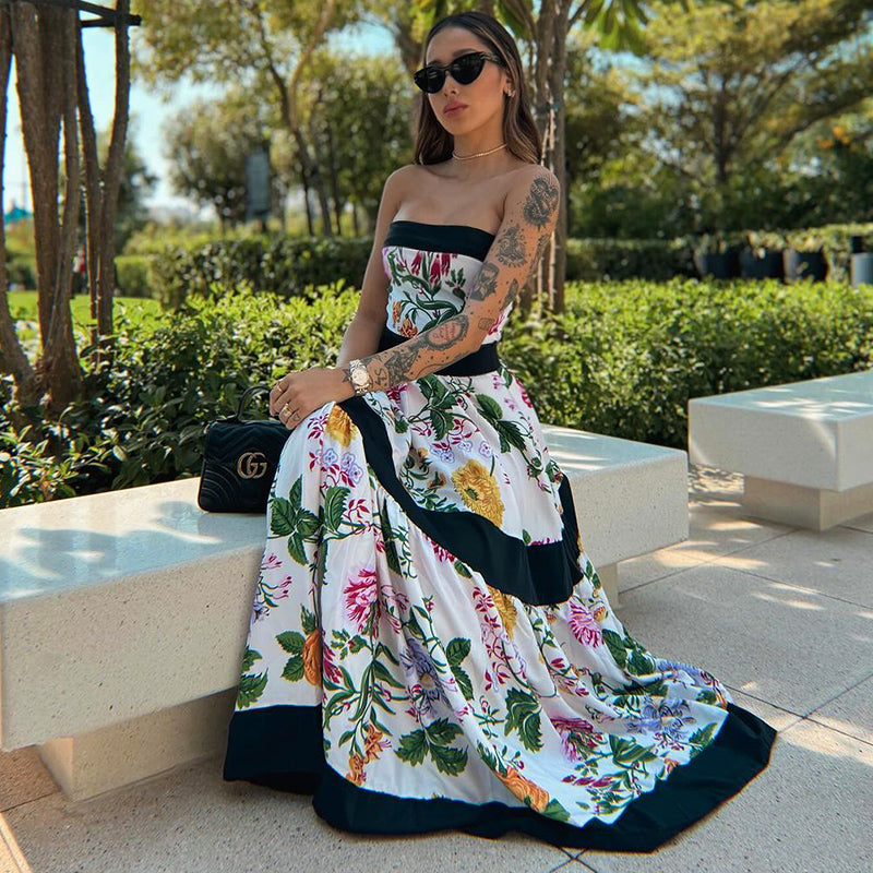 One-piece swimsuit with dropped shoulder straps, tie back, color block print and skirt