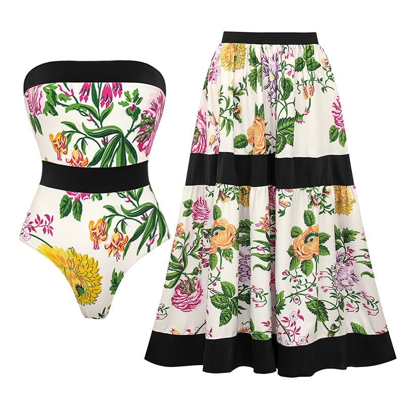 One-piece swimsuit with dropped shoulder straps, tie back, color block print and skirt