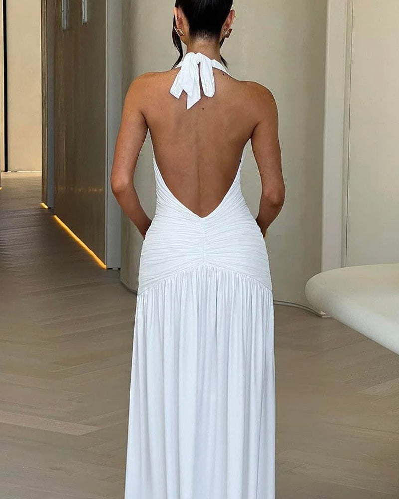 White holiday dress with deep V-neck, open back, ruched detailing, and thigh slit, halter style